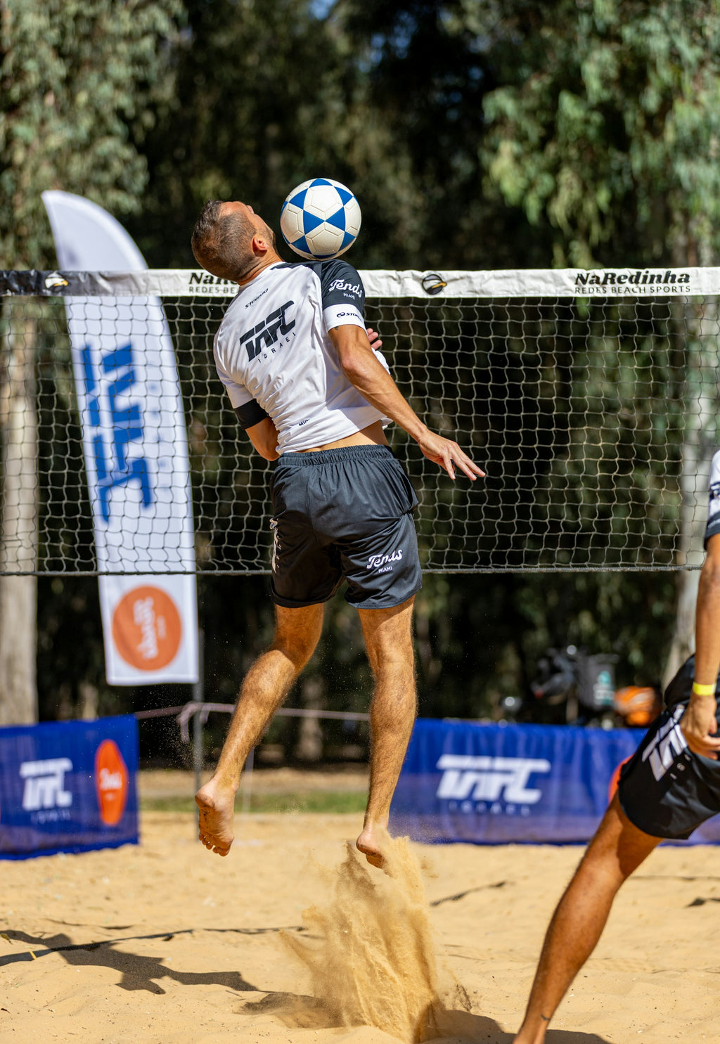 שחקן מקצועי משחק עם כדור פוצ'יוולי של המותג מיקאסה בצבע לבן וכחול